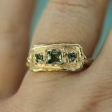greens sapphires set in 10k yellow gold band on hand