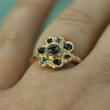 gold floral designed ring on hand with sapphires
