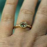 oval light green sapphire bubbly organic setting in 14k yellow gold on hand.