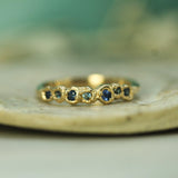 round blue sapphires set in 14k yellow gold band