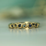 many different shades of blue set in solid 14k yellow gold