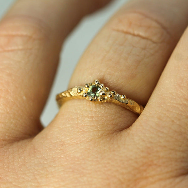 green sapphire ocean inspired gold ring on hand 