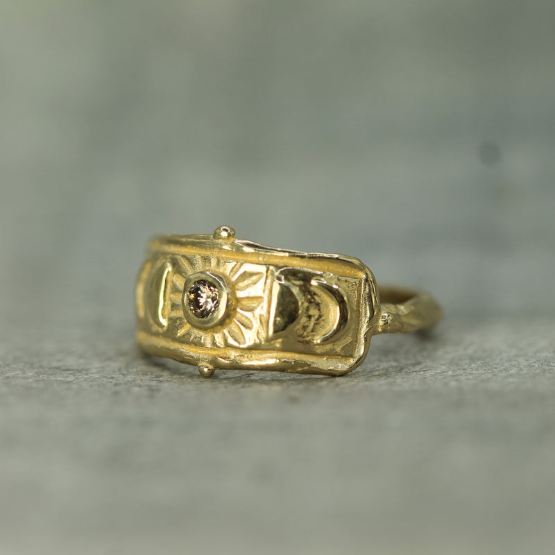 hand carved moon phases onto a yellow gold ring 