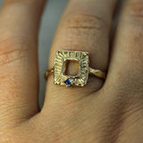 gold open frame inspired ring on hand