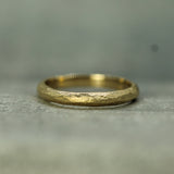 Gold ring with a textured surface on a gray background