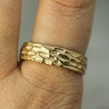 yellow gold textured wedding band on hand