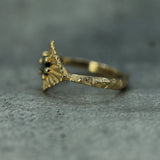 Gold ring with jasper textured band on a gray textured background