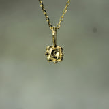 Gold necklace with a square pendant moon on a blurred background