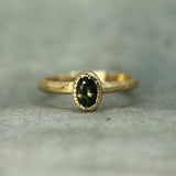 green oval sapphire ring in 14k yellow gold