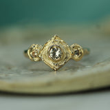 Gold ring with a sapphire on a textured surface