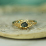 raw sapphire with adjacent brilliant cut green sapphire set in 14k yellow gold