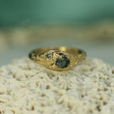 Gold ring with sapphires on a textured surface