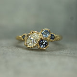 14k yellow gold ring with diamond and sapphires on a textured surface