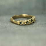 gold textured wedding band with teal sapphires