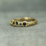 Gold ring with embedded blue stones on a textured gray background