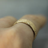 sand textured yellow gold ring on finger