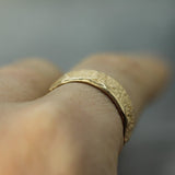 sand textured yellow gold ring on finger