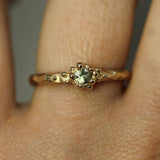 green sapphire with an ocean inspired setting in solid 14k gold on hand