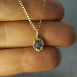 raw sapphire pendant in 10k yellow gold on hand 