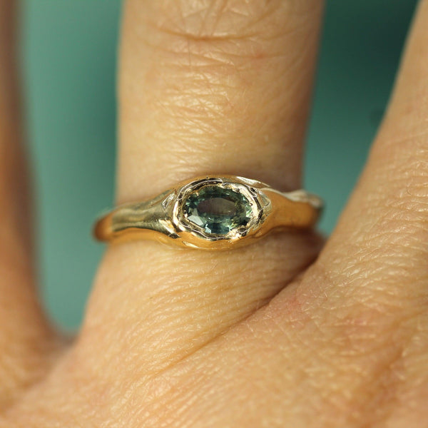 gold sapphire ring on hand 