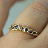blue sapphires set into yellow gold shown on hand 