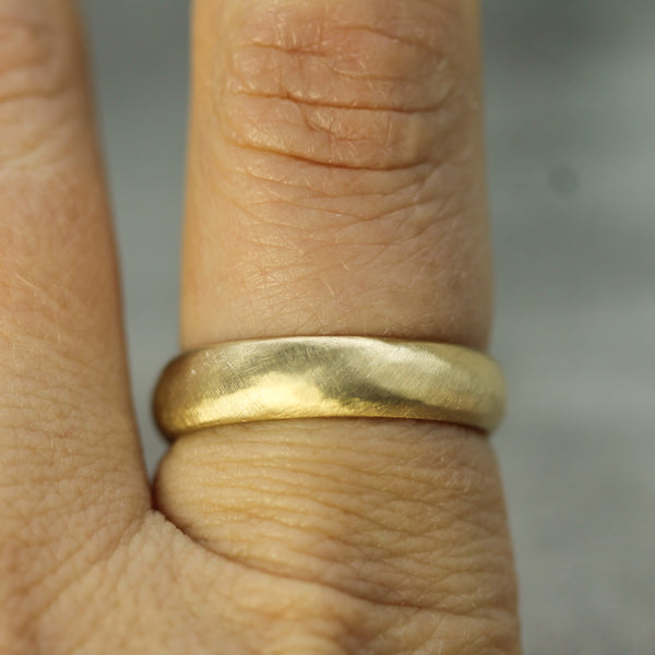 smooth band in 10k yellow gold with a matte finish on hand 