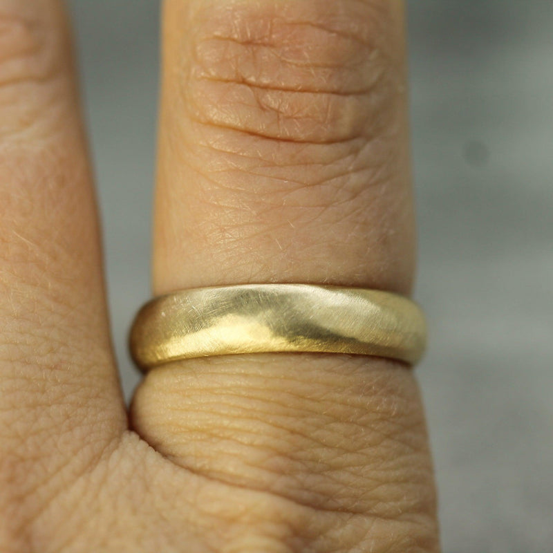 smooth band in 10k yellow gold with a matte finish on hand 