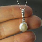 pearl pendant with silver bail on hand