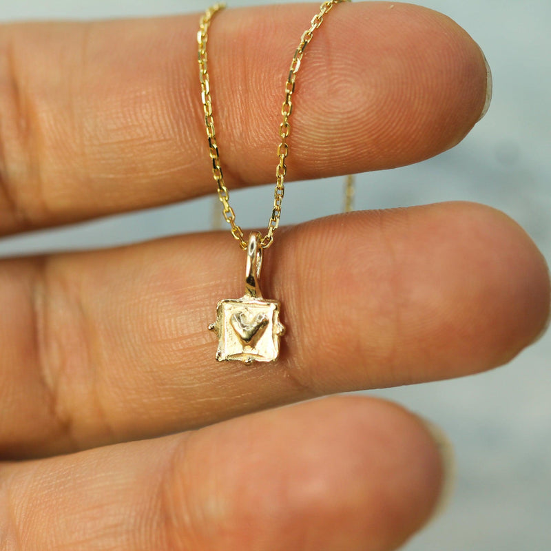 ancient love gold pendant on hand 
