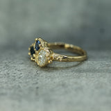 one of a kind engagement ring with an oval diamond and two sapphires 