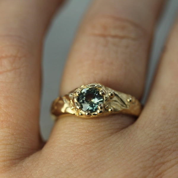 blue-green sapphire gold ring on hand 
