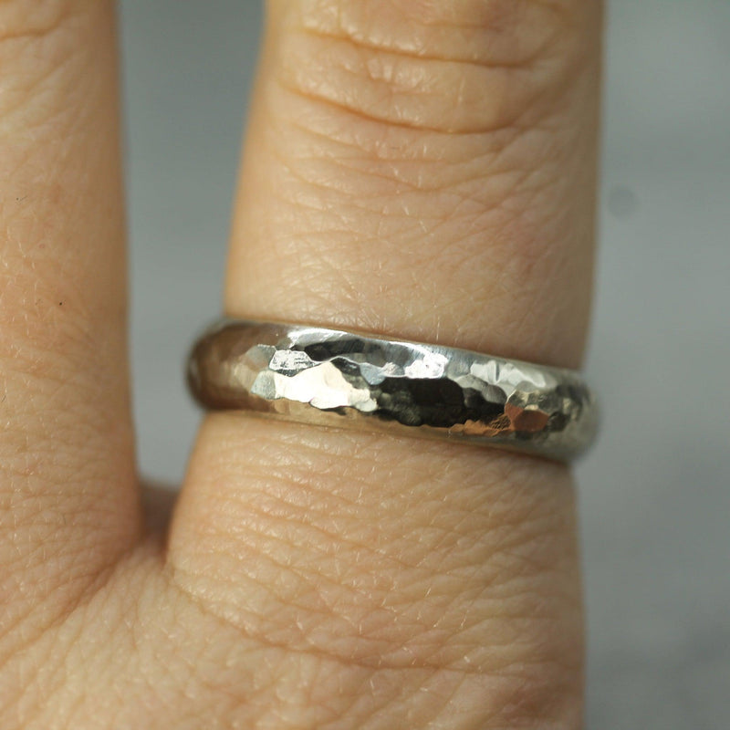 hammered white gold wedding band on finger 
