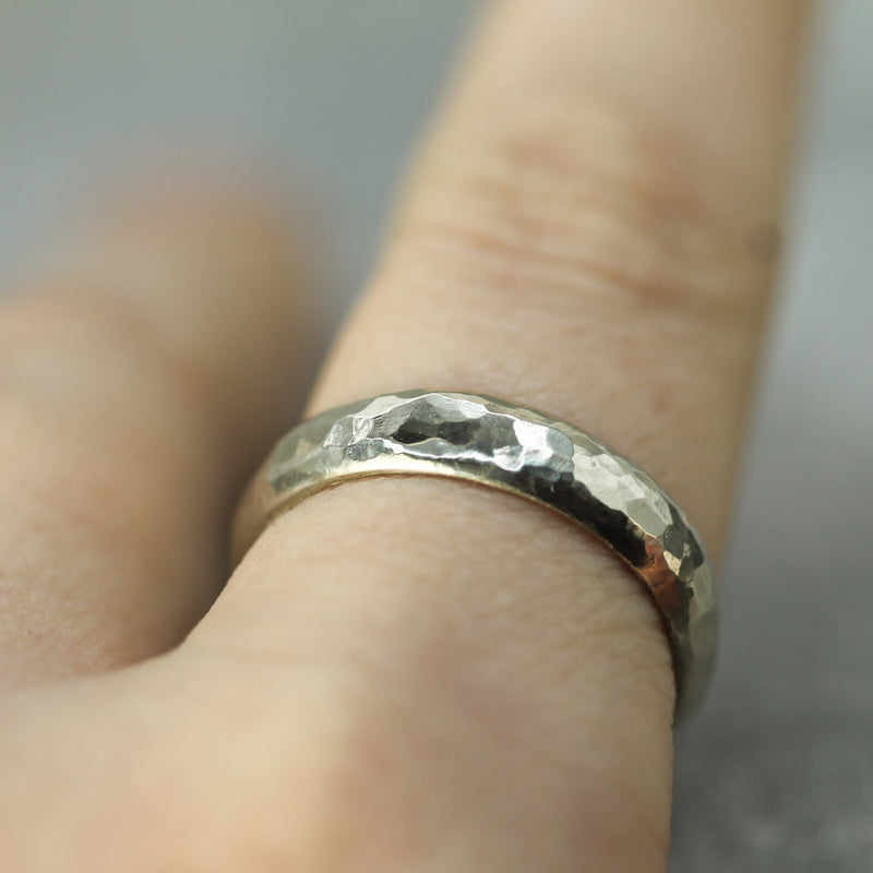 hammered white gold band showing the dome on a finger 