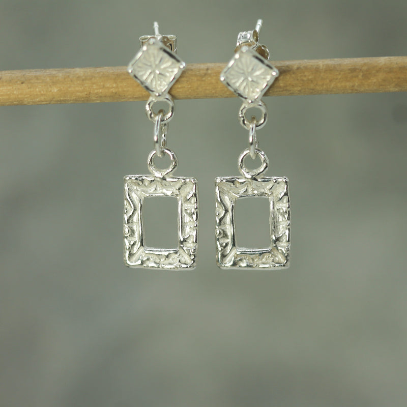 holding glimmer silver square earrings 