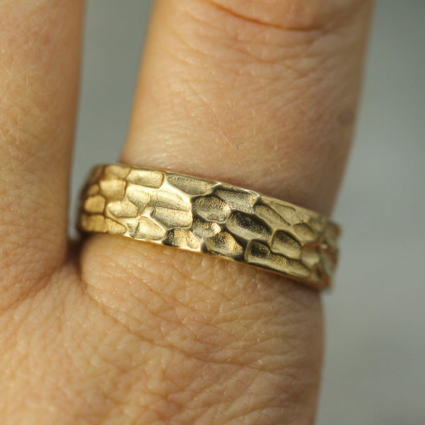 yellow gold textured wedding band on hand 