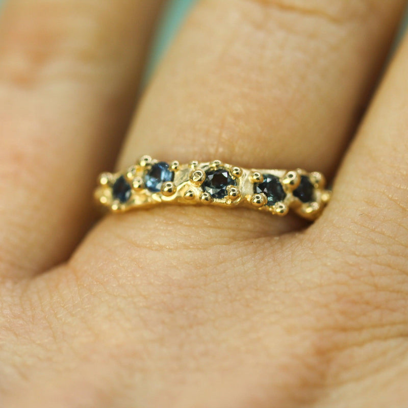 gold band with blue sapphires on hand 