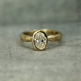 14k yellow gold ring with a lab-grown diamond on a gray surface