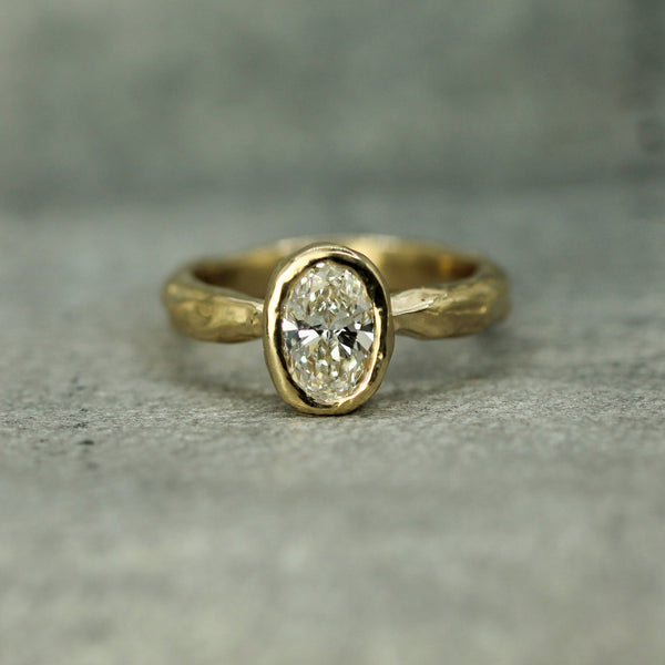 14k yellow gold ring with a lab-grown diamond on a gray surface
