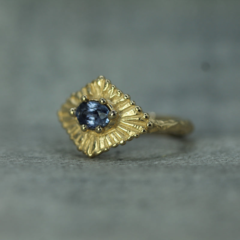 gold sapphire celestial ring pictured side on to show the rings texture and hand carving 