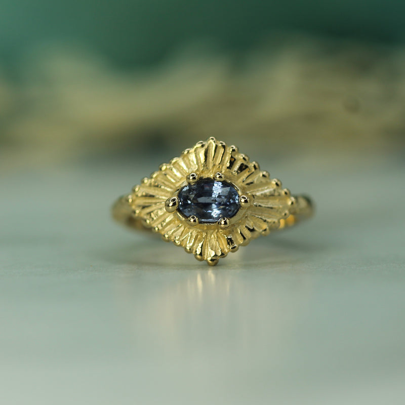 yellow gold celestial ring with a light blue sapphire 