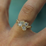 Gold ring with three diamonds on a finger against a blurred background