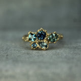Gold ring with blue sapphires 
on a gray background