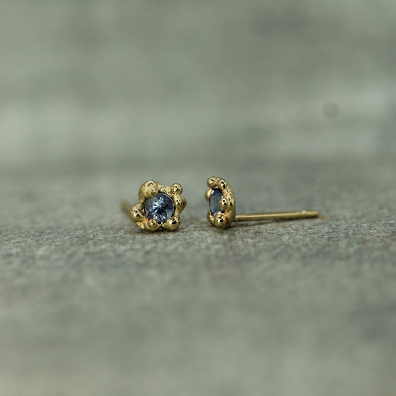 oceany bubbles surround blue sapphires in a yellow gold setting 