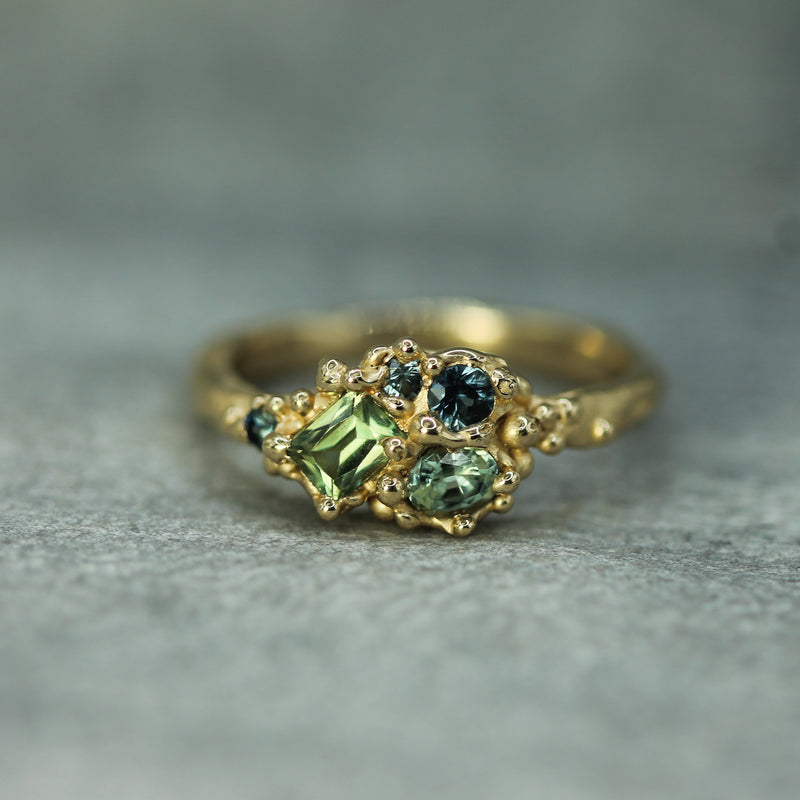 ocean inspired cluster ring with green and blue sapphire set in 14k yellow gold
