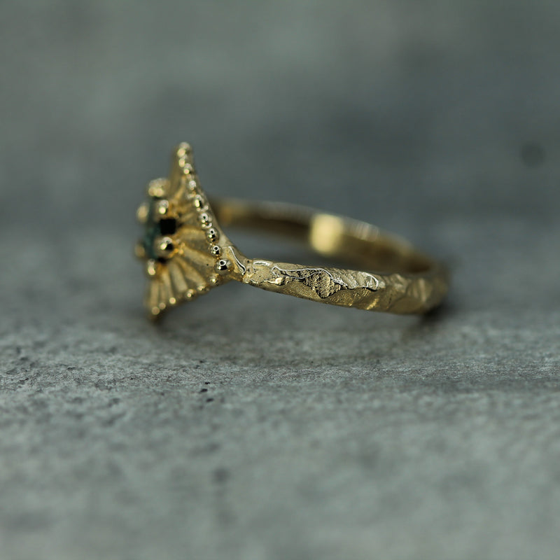 Gold ring with jasper textured band  on a gray textured background