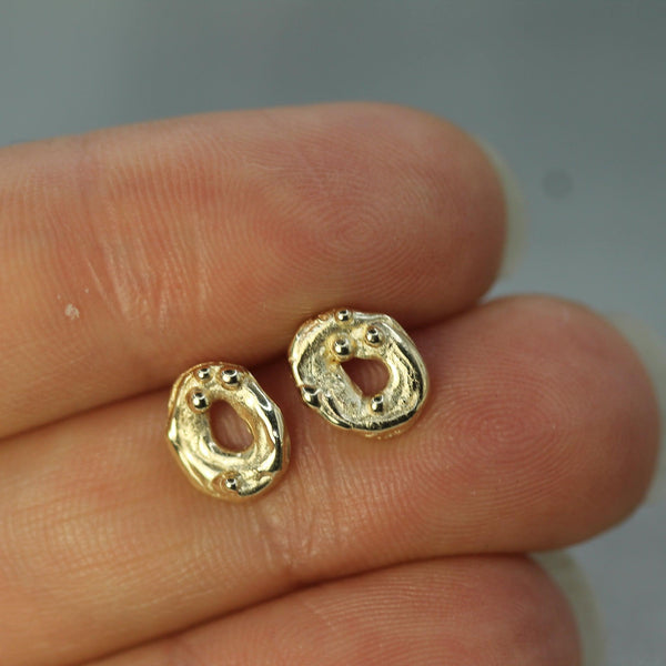 moon swirl gold studs on hand