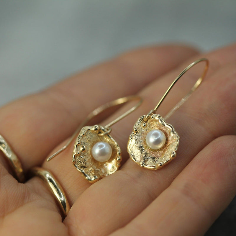 golden pearl earrings on hand 