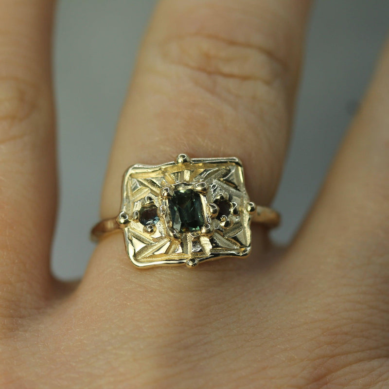 gold sapphire ring on hand 