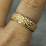 14k yellow gold sand textured band on hand 