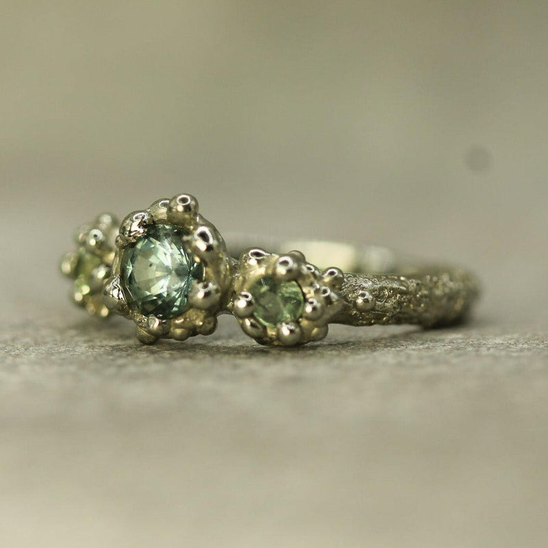 bubbly ocean inspired engagement ring with three teal sapphires and 19k white gold 